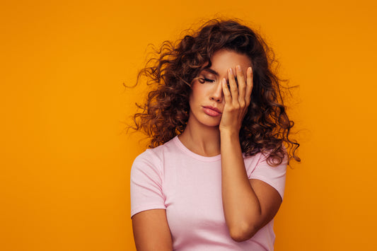 Woman feeling tired but wired, struggling to get to sleep 