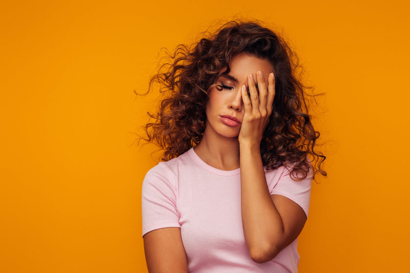 Woman feeling tired but wired, struggling to get to sleep 